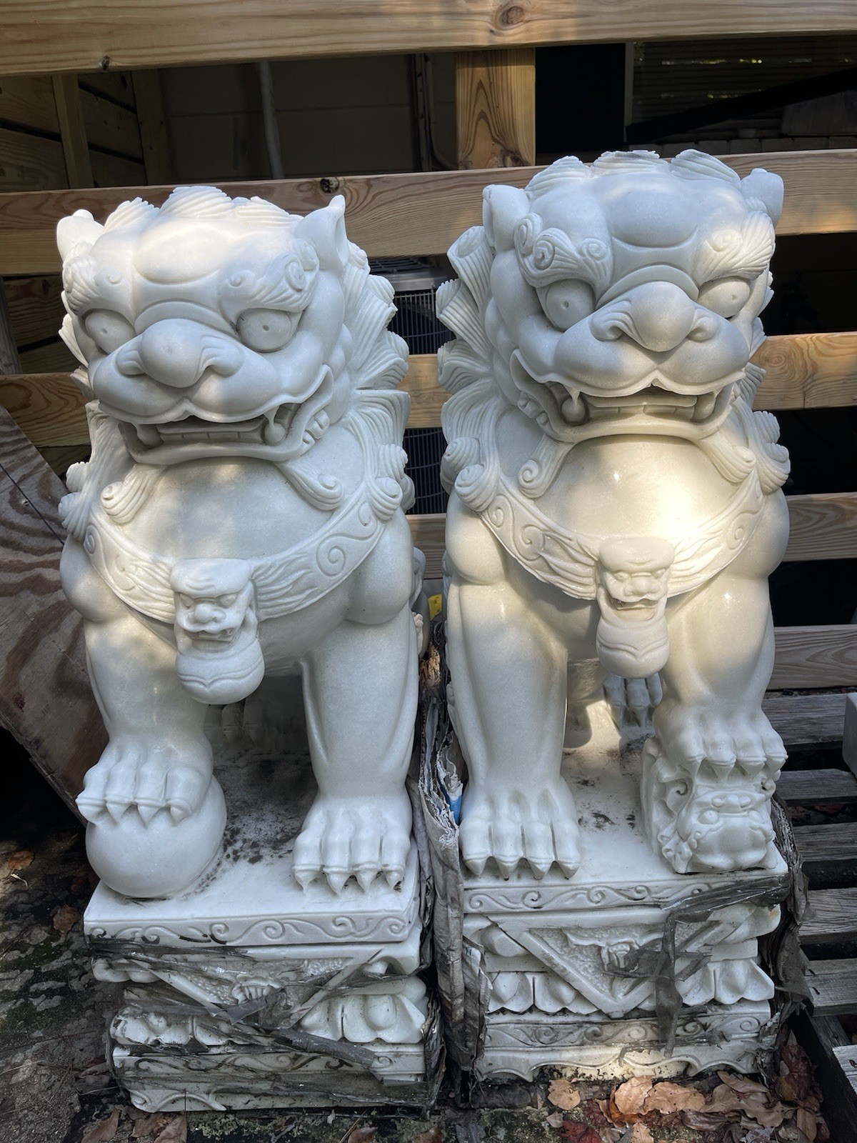 A pair of Chinese guardian lion statues made of genuine white stone. A pair of Chinese guardian lion statues made of genuine white stone.