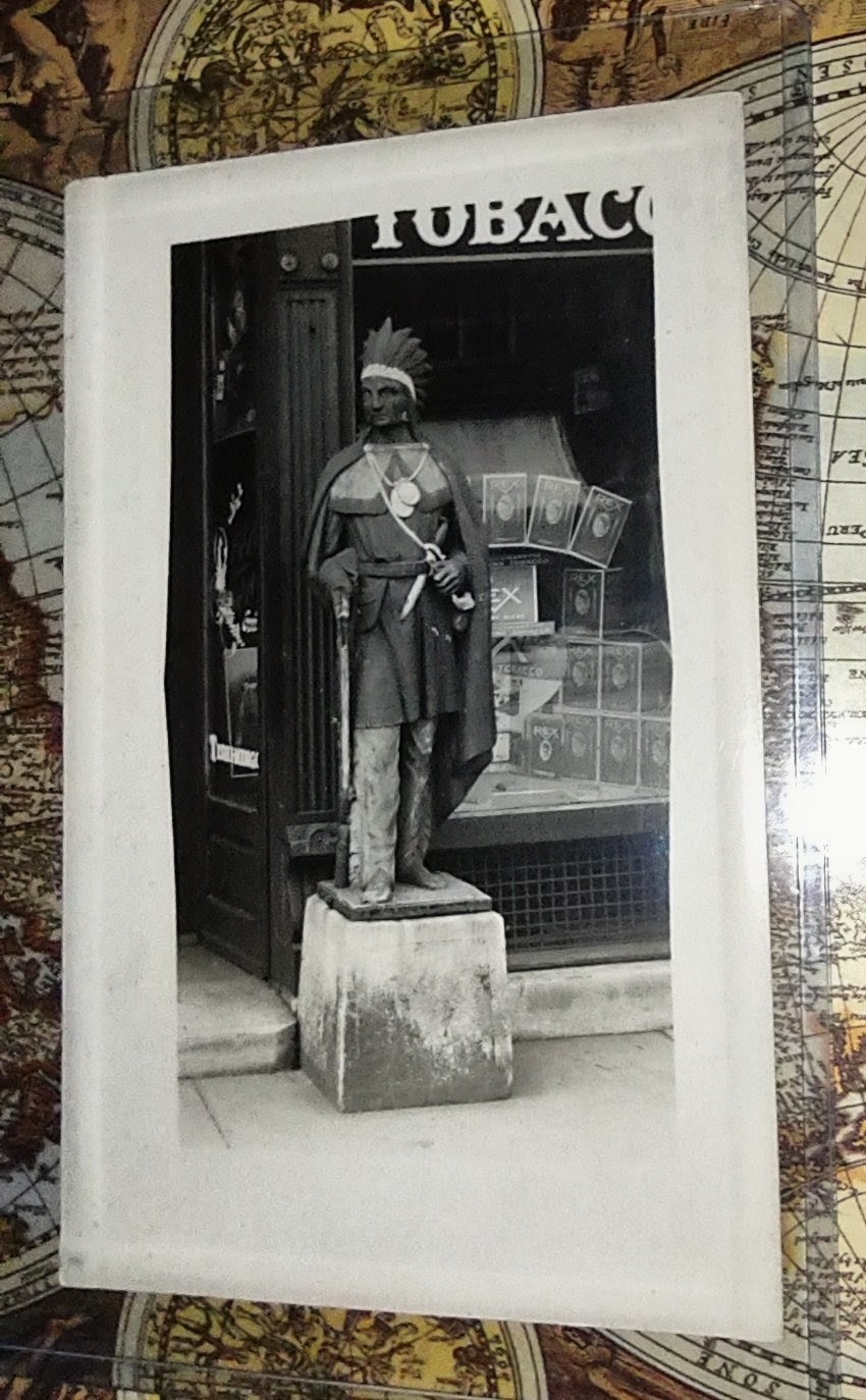 BEST RPPC OF CIGAR STORE INDIAN ON EBAY.  HE HAS A RIFLE BIG KNIFE 2 MEDALLIONS.