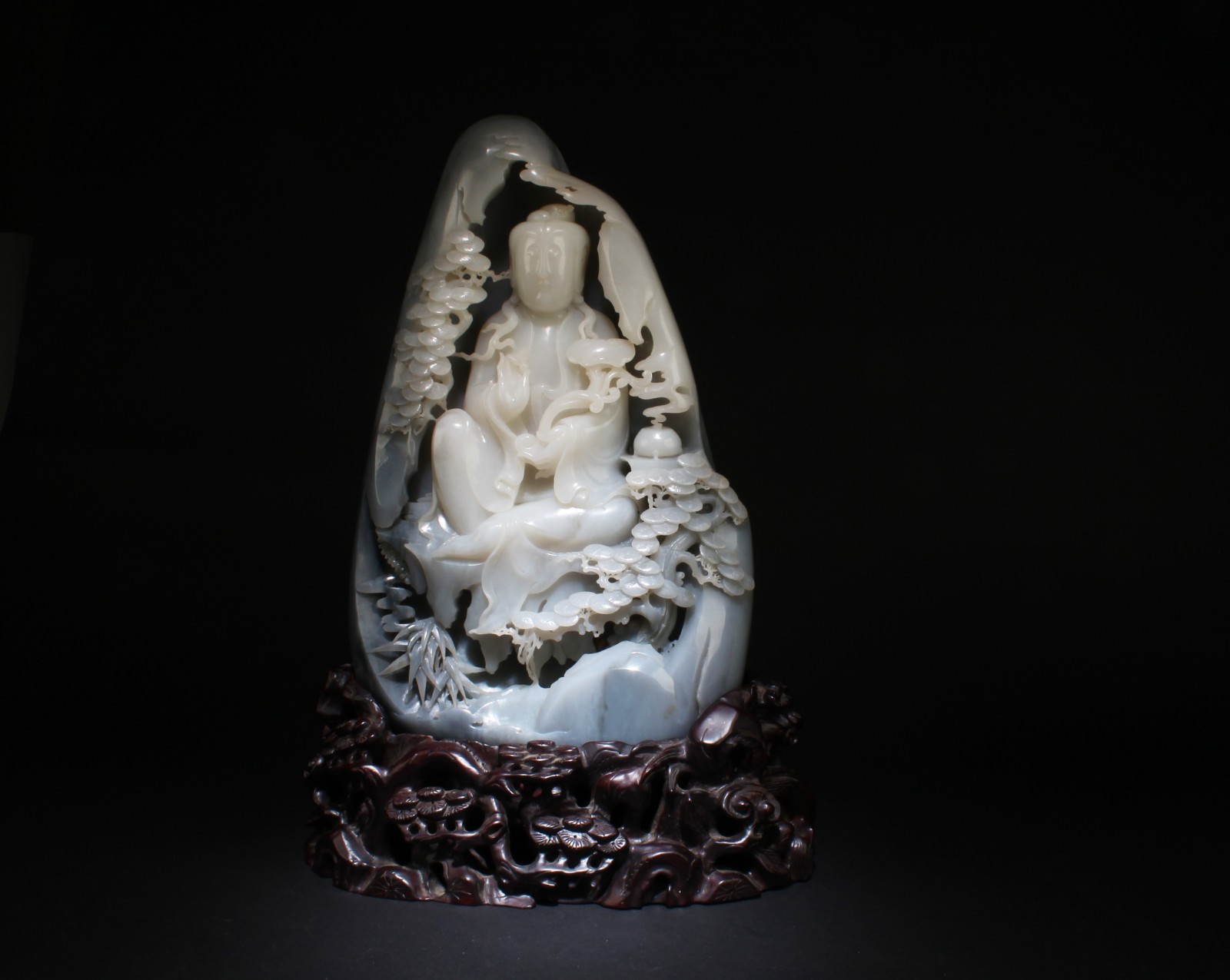 A Massive Carved Hetian Jade Guanyin with Fitted Stand A Massive Carved Hetian Jade Guanyin with Fitted Stand